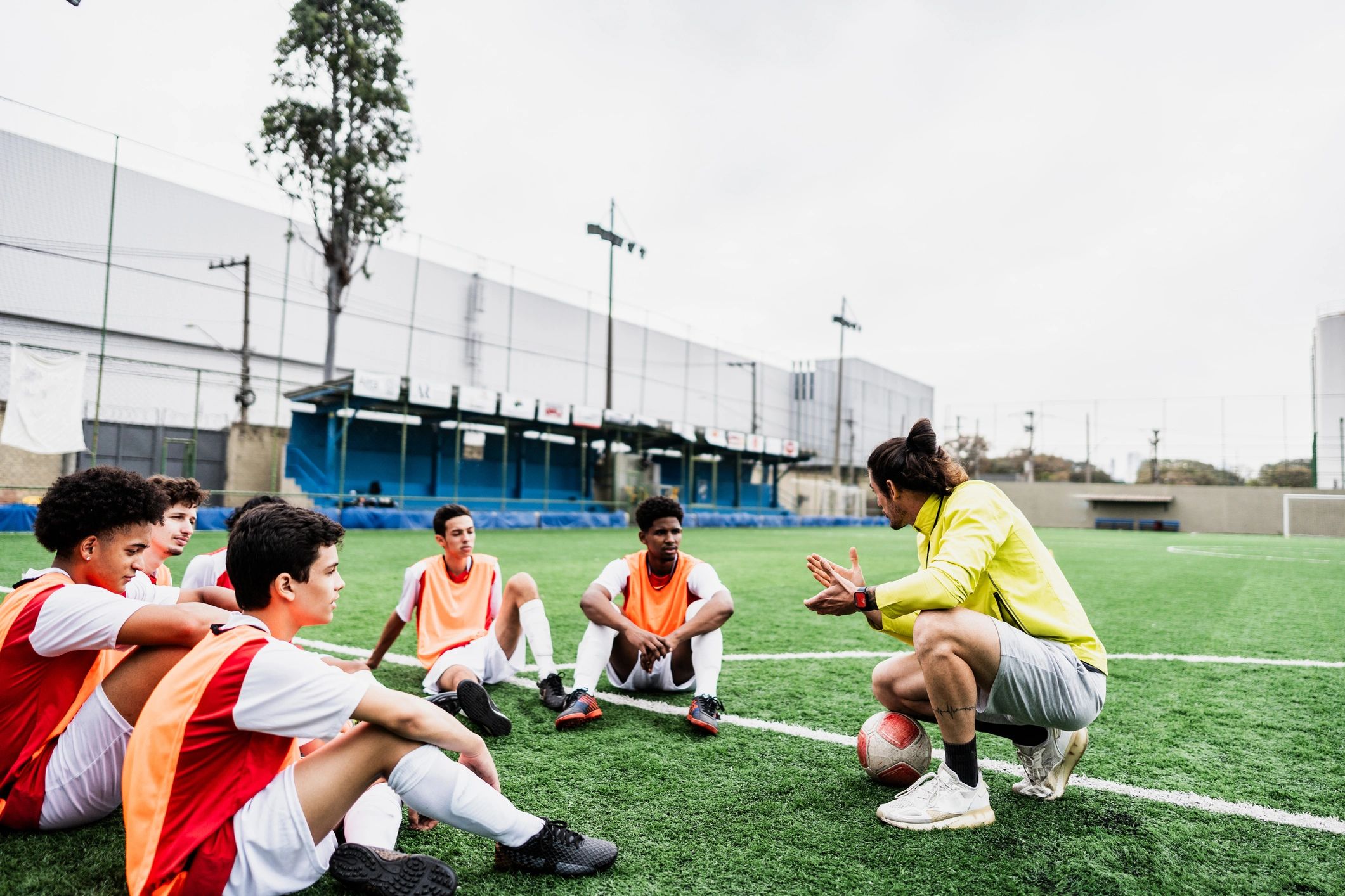 Coach talking with soccer players during training on a soccer field